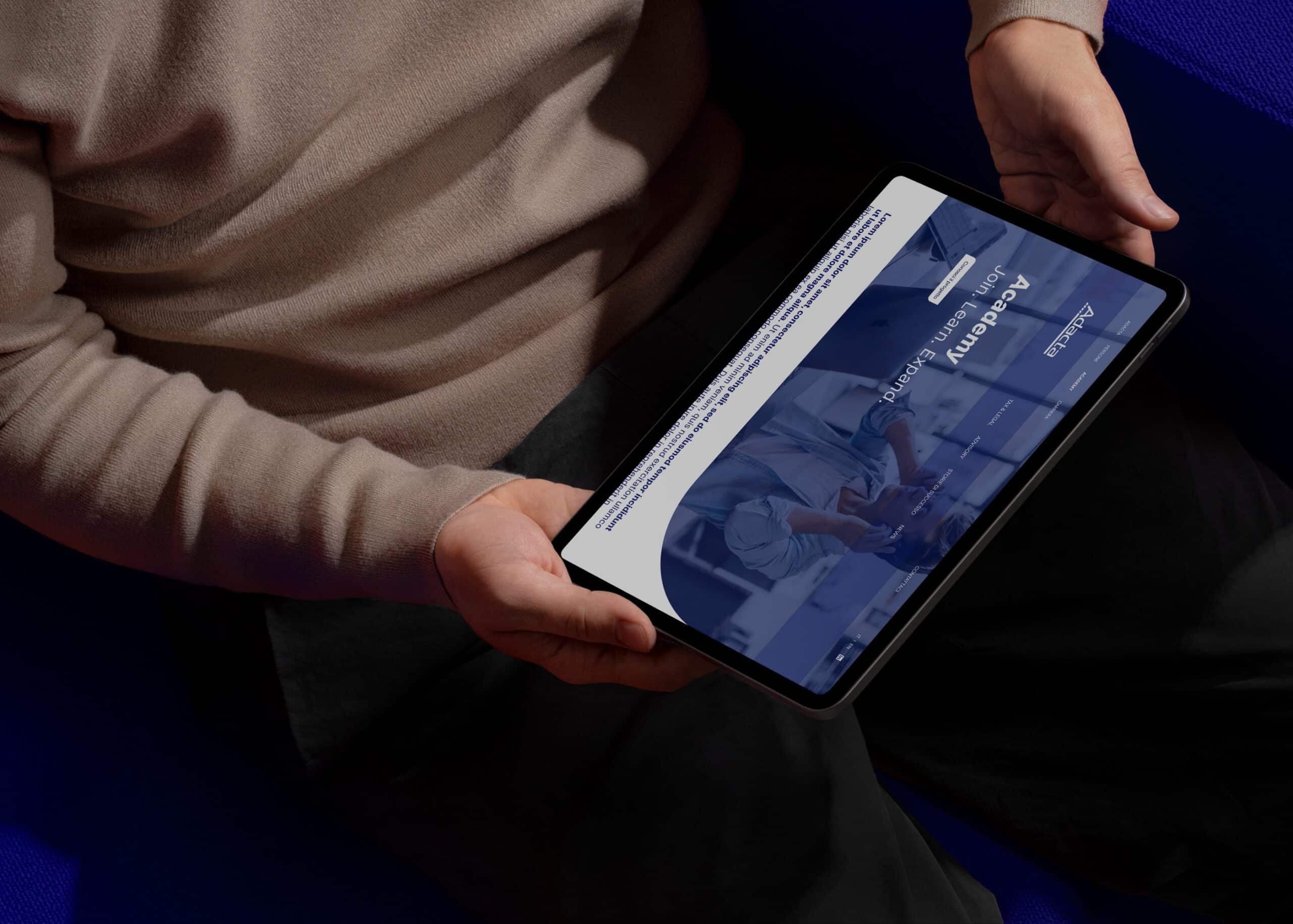 Persona con tablet in mano mentre consulta la piattaforma di formazione di Adacta.