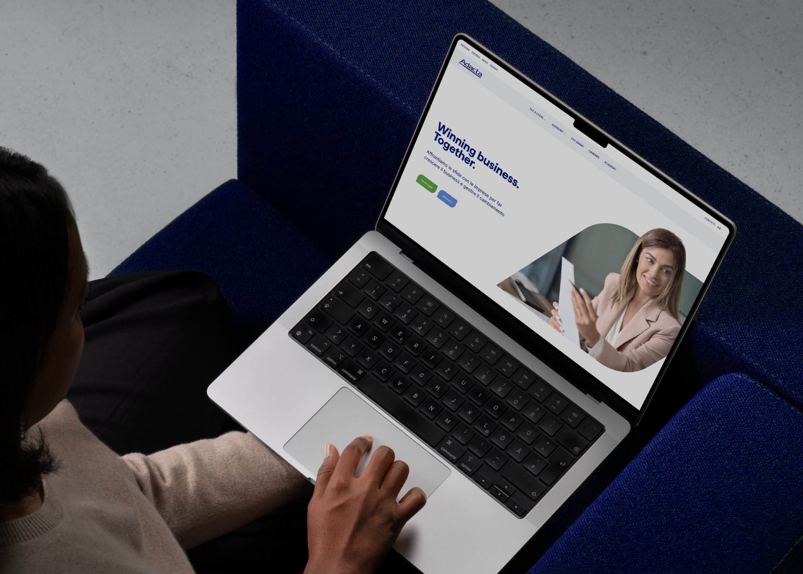 Persona al computer che consulta il nuovo sito di Adacta.